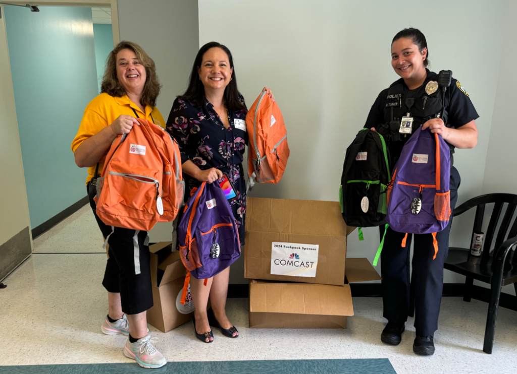 Three women holding backpacks