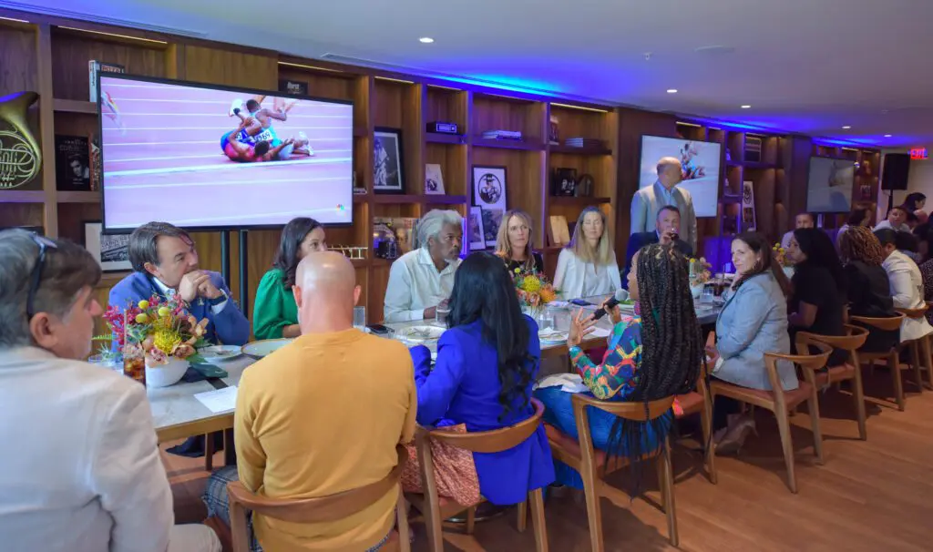 a group of people sit at a long rectangular table