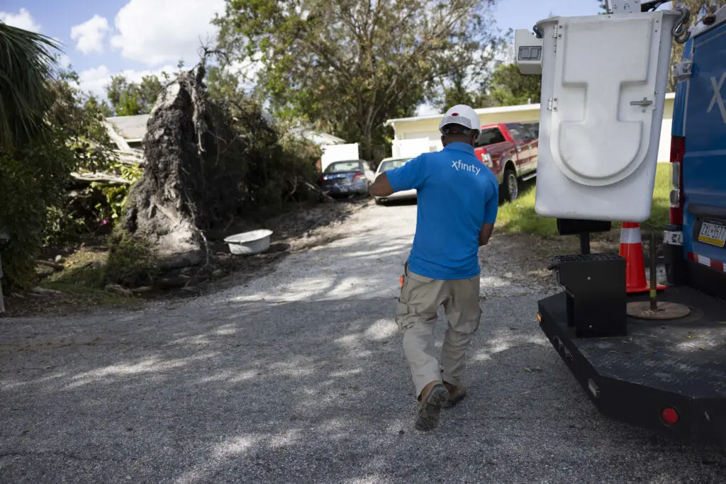 An Xfinity technician surveys damage and plans repairs.