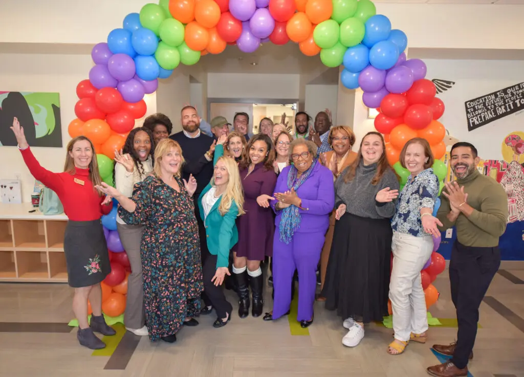 people posing for a picture under a balloon arch