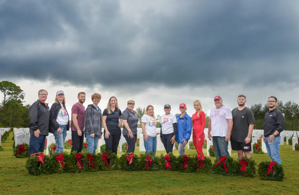 people posing for a picture with wreaths at their feet