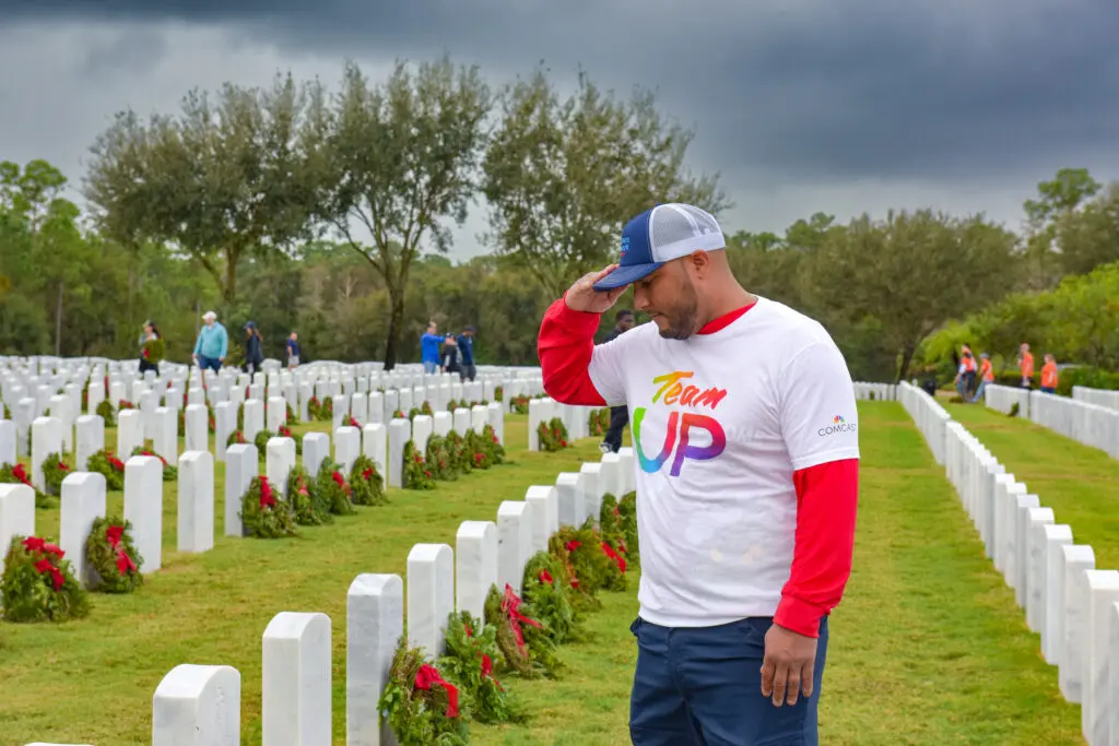 man salutes veteran at cemetery