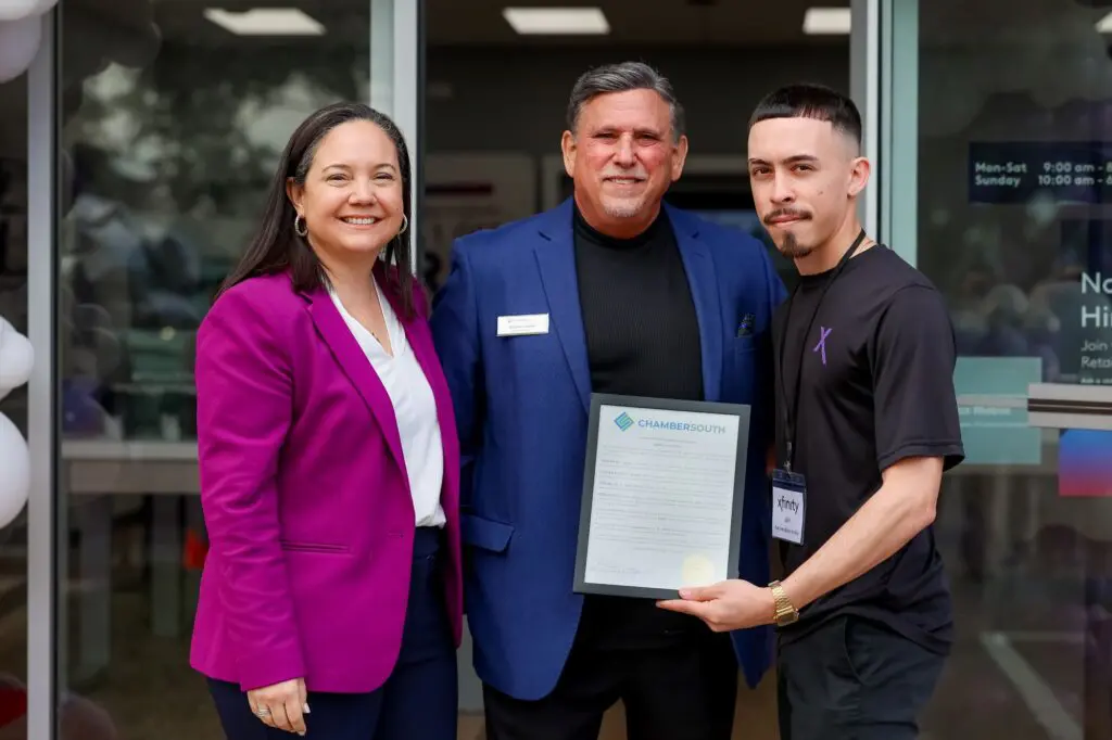 two men and a woman pose for a picture holding a proclamation in hand