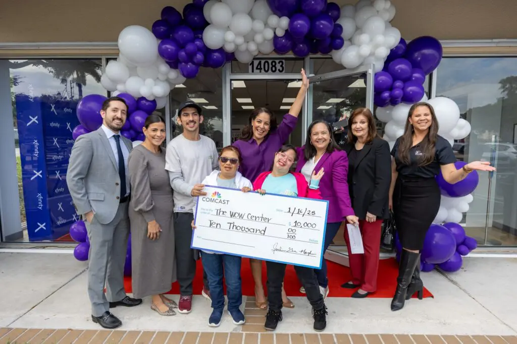 group of adults and children pose for a picture with a big donation check