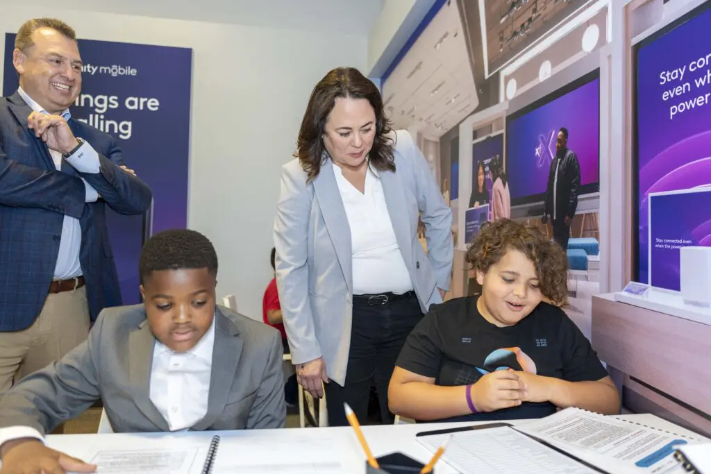 Jeff Buzzelli, Regional Senior Vice President, and Jackie Guerry Maybeck, Vice President of Marketing, assist two students working in student business roles and practicing youth leadership at JA Biztown.