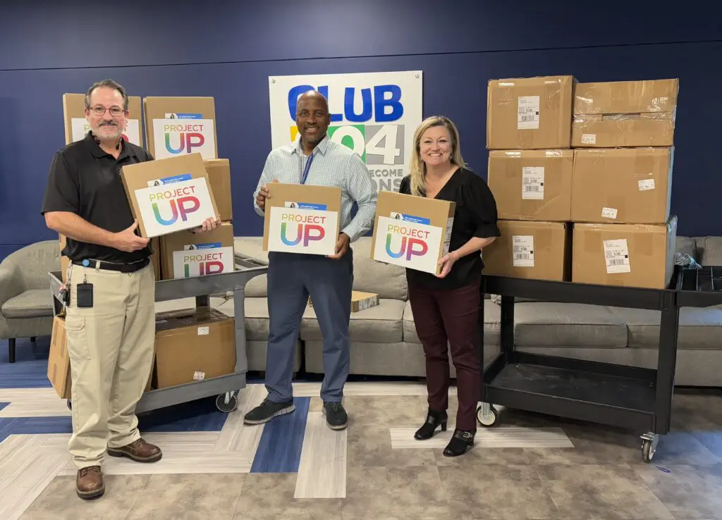 three adults holding laptops