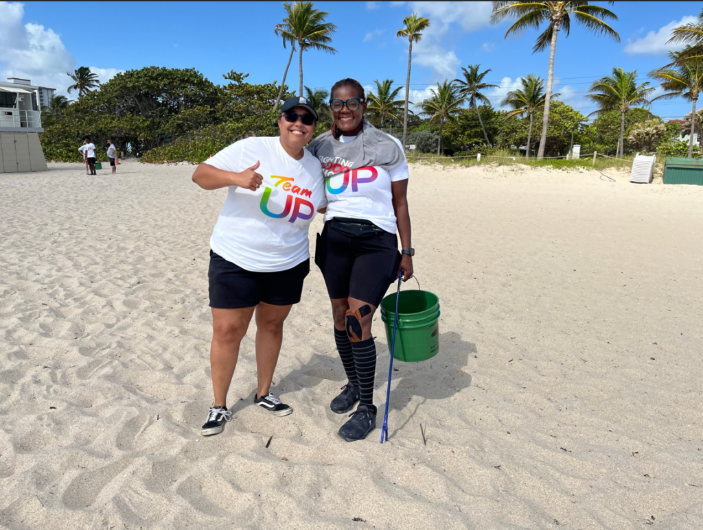two women at the beach cleaning
