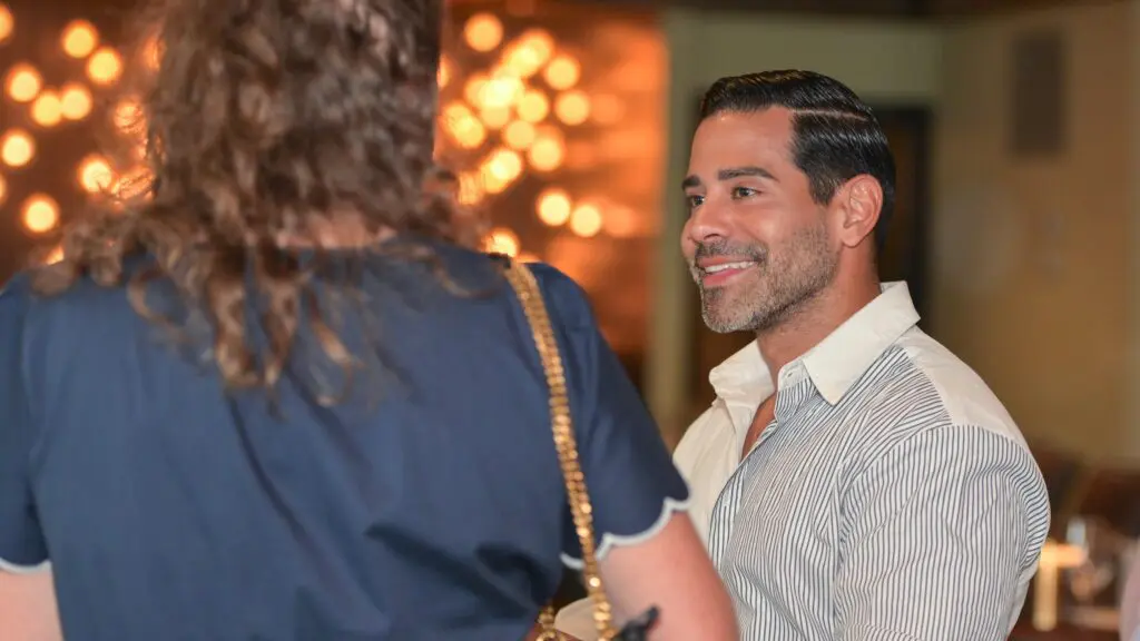 man smiling and talking to a woman