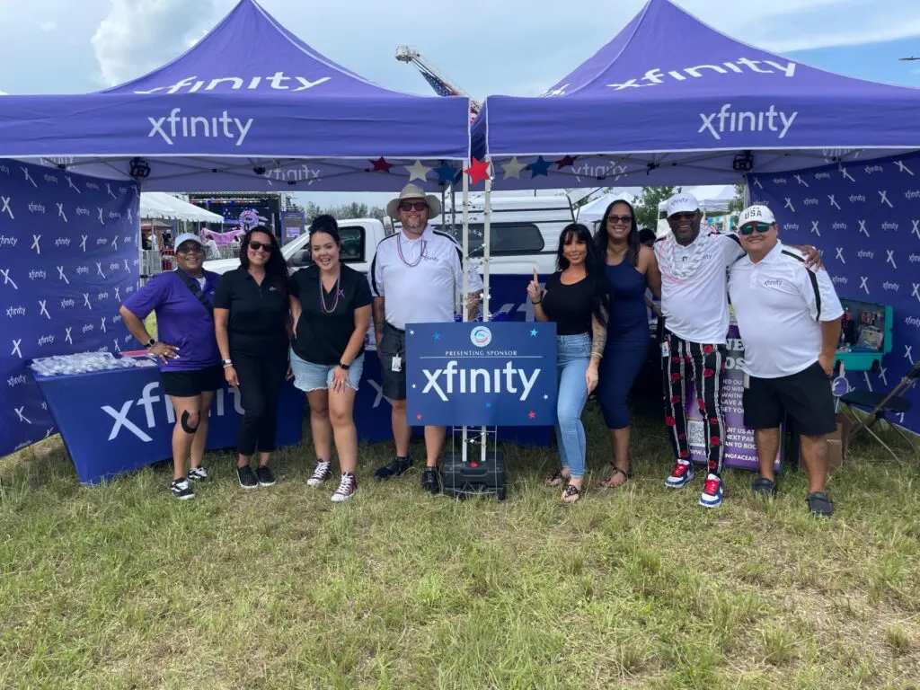 people posing for a picture under xfinity tents
