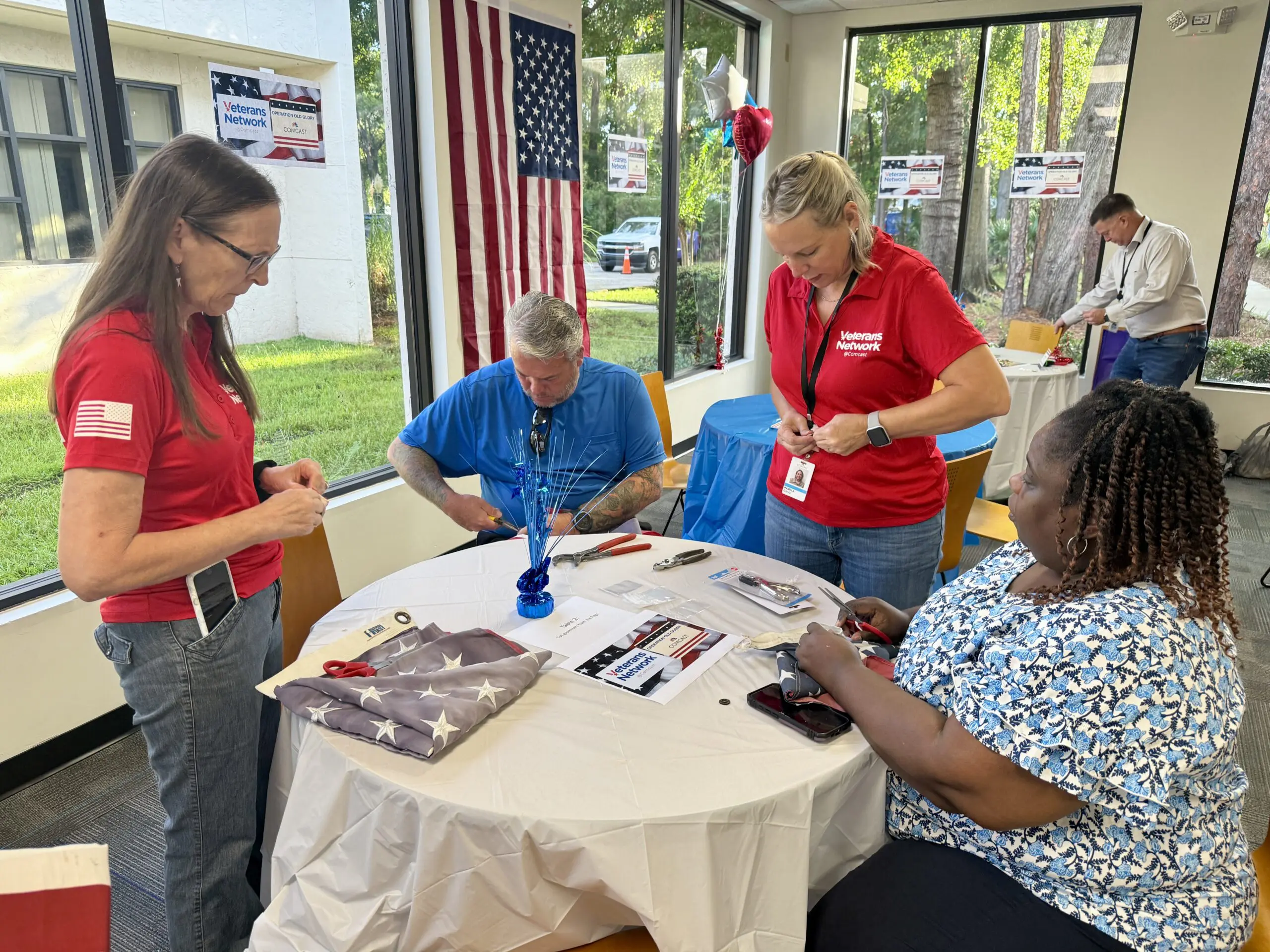 people around a table making keepsakes from grommets of retired flags.