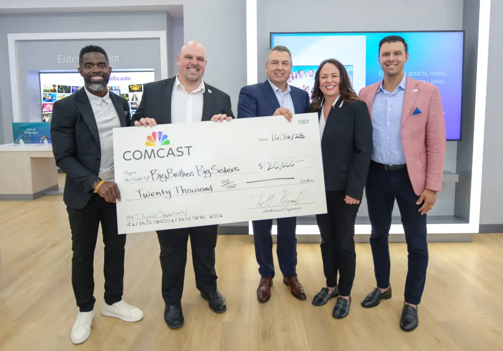 Five people posing for a picture with a big check