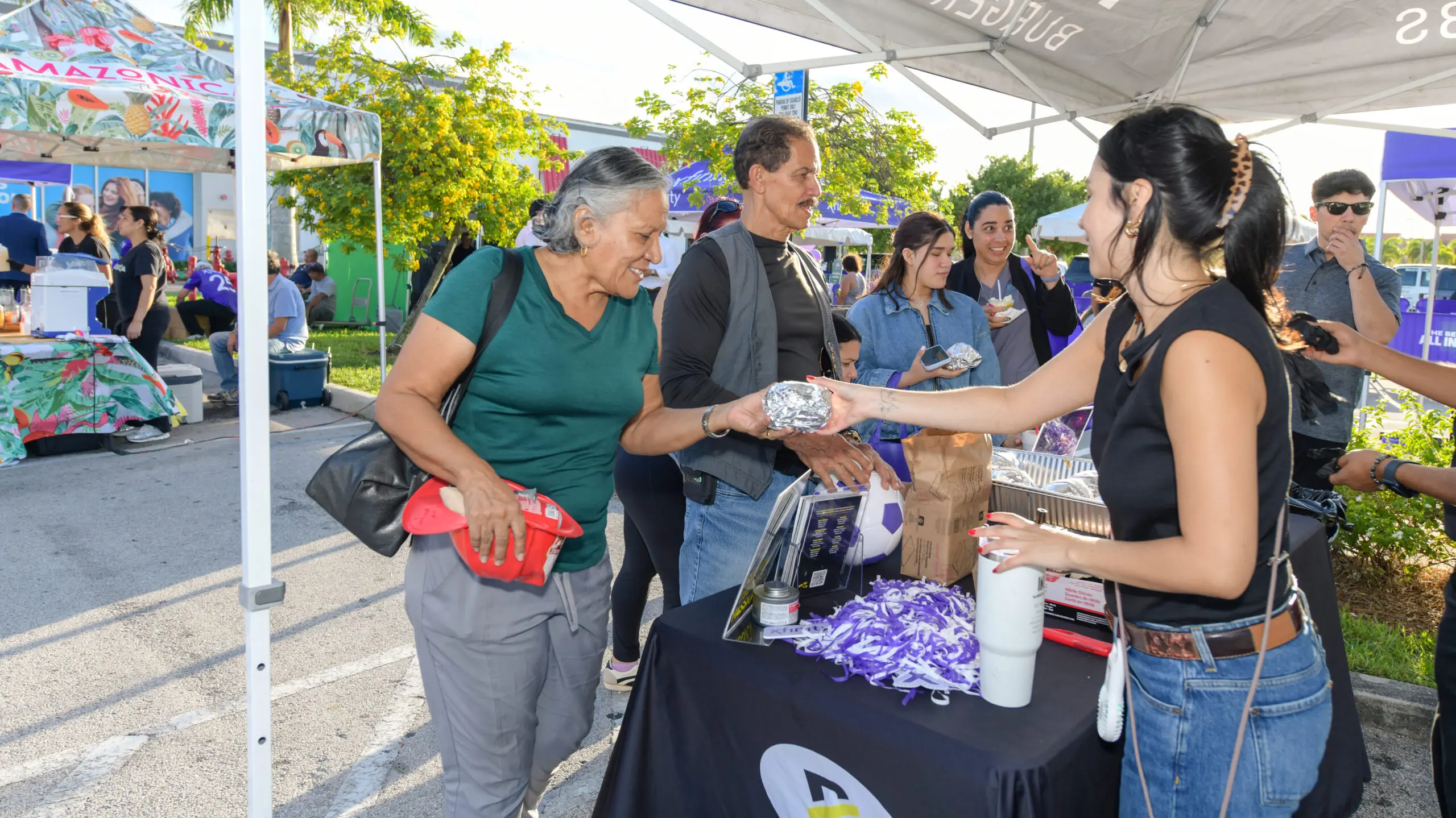 People at an event getting gifts.