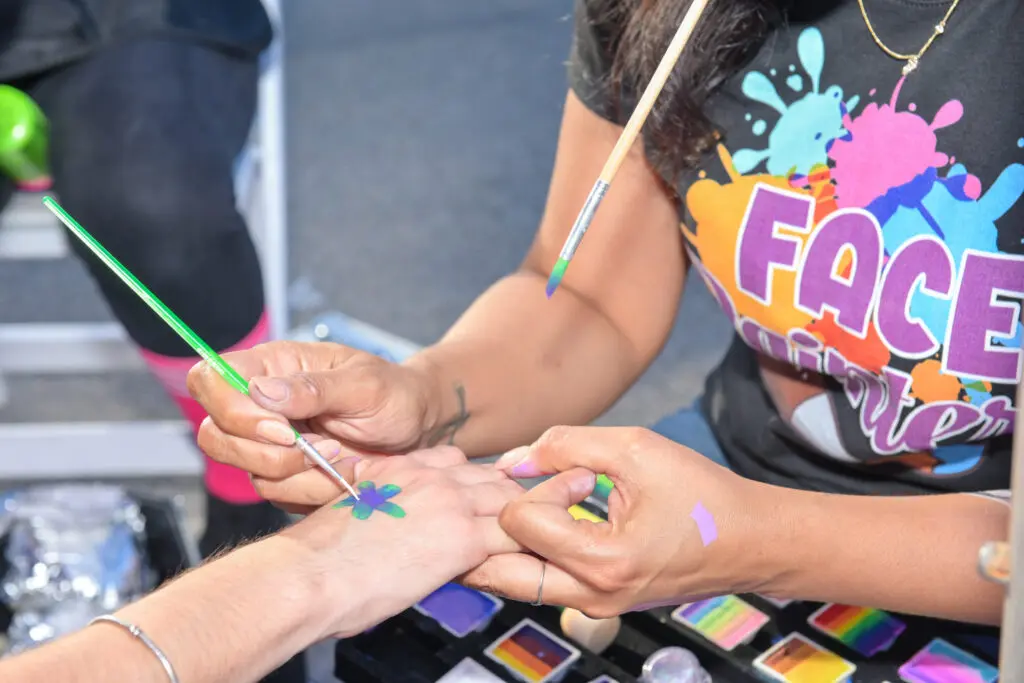 hands being painted at a festival