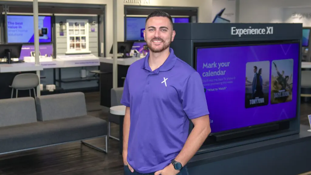 Brent Delawter smiling inside the Lady Lake Xfinity Store, standing near a display of Xfinity products.