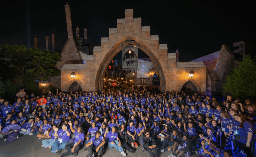 hundreds of teenagers sitting on the floor posing for a picture