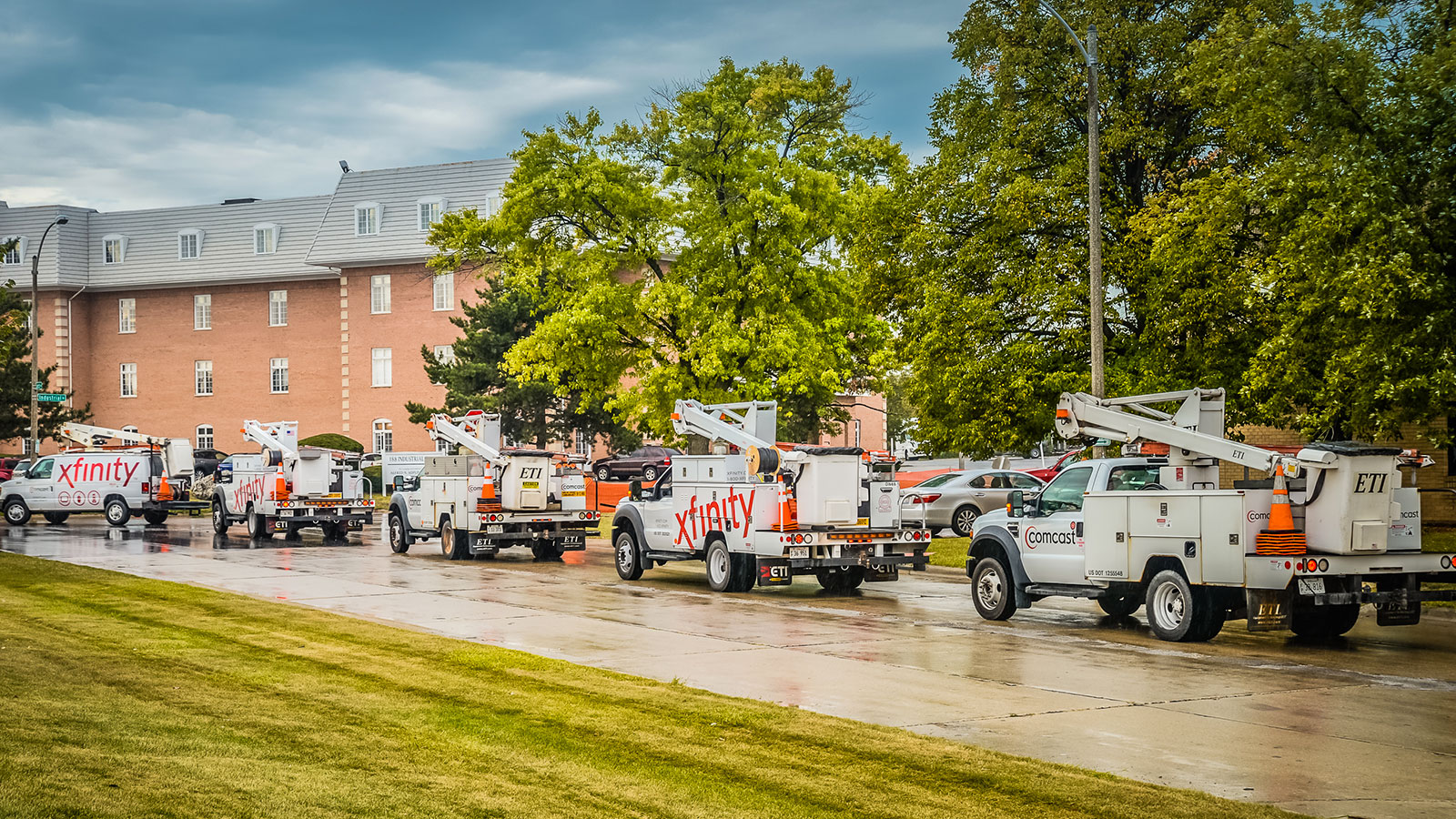 Xfinity trucks lined up along a street.