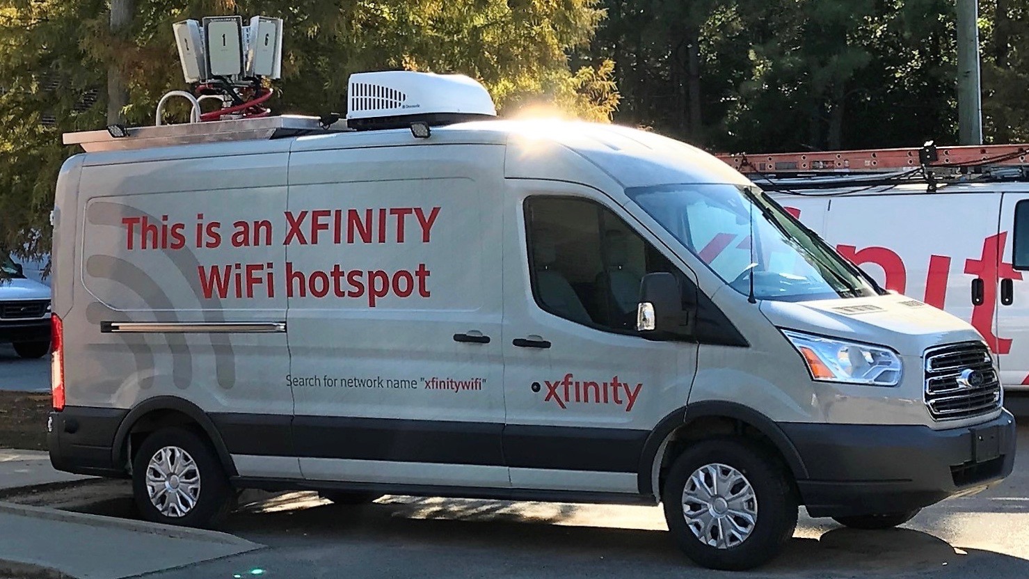 An Xfinity WiFi Hotspot van parked in a parking lot.