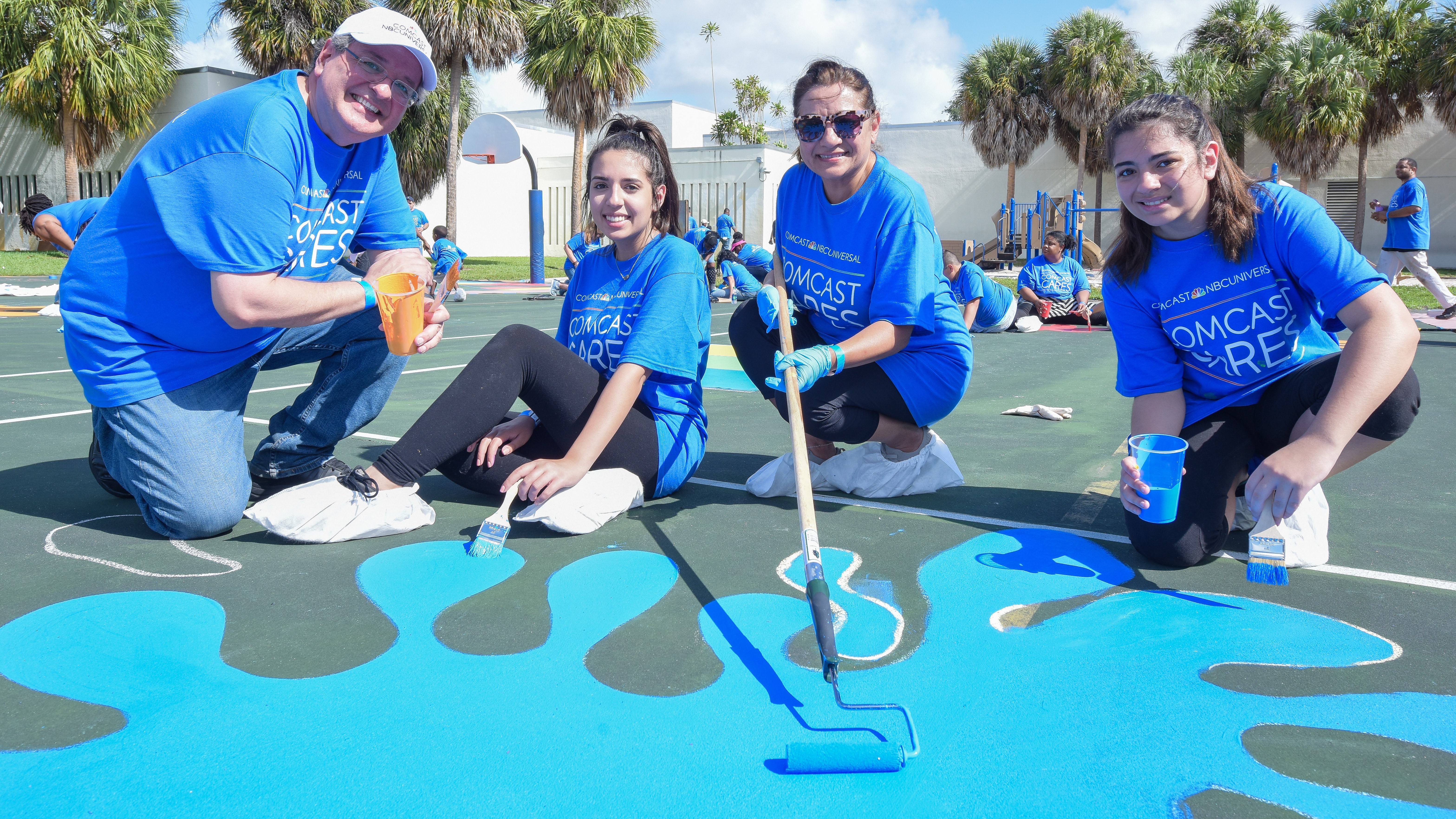 Comcast Cares Day volunteers paint a playground.