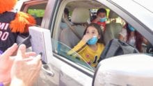 Children in a car exclaim with excitement