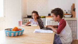 Two students do their homework at a kitchen table