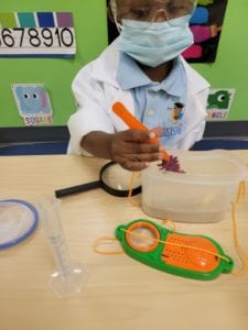 Young child playing with science toys