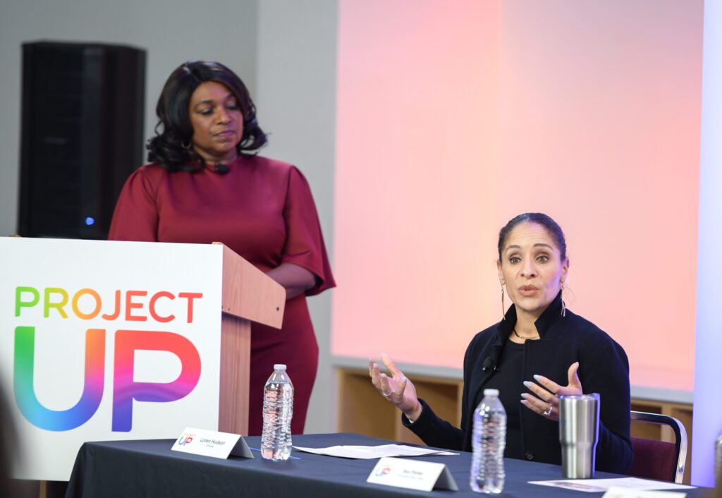 Moderator looking over a panelist speaking.