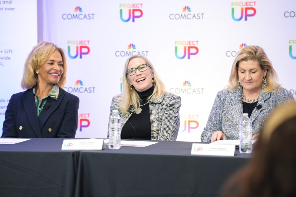 Three women on the panel sitting next to eachother at a table.