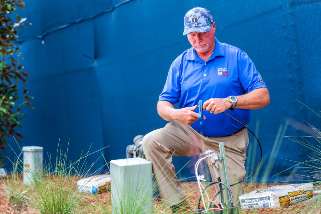 A man working with cable on a golf course