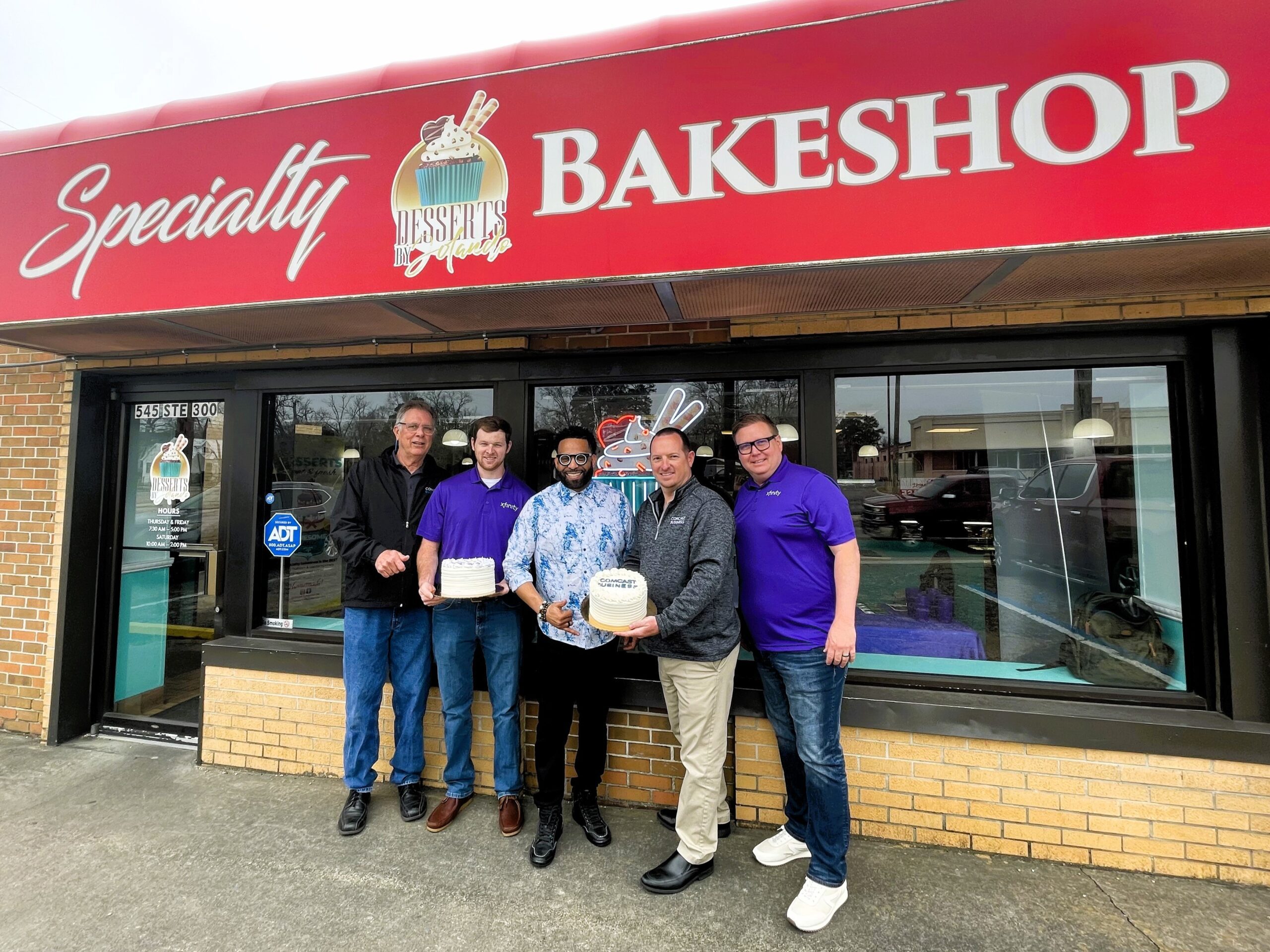 Jolando and Comcast reps posed outside Jolando's bake shop.