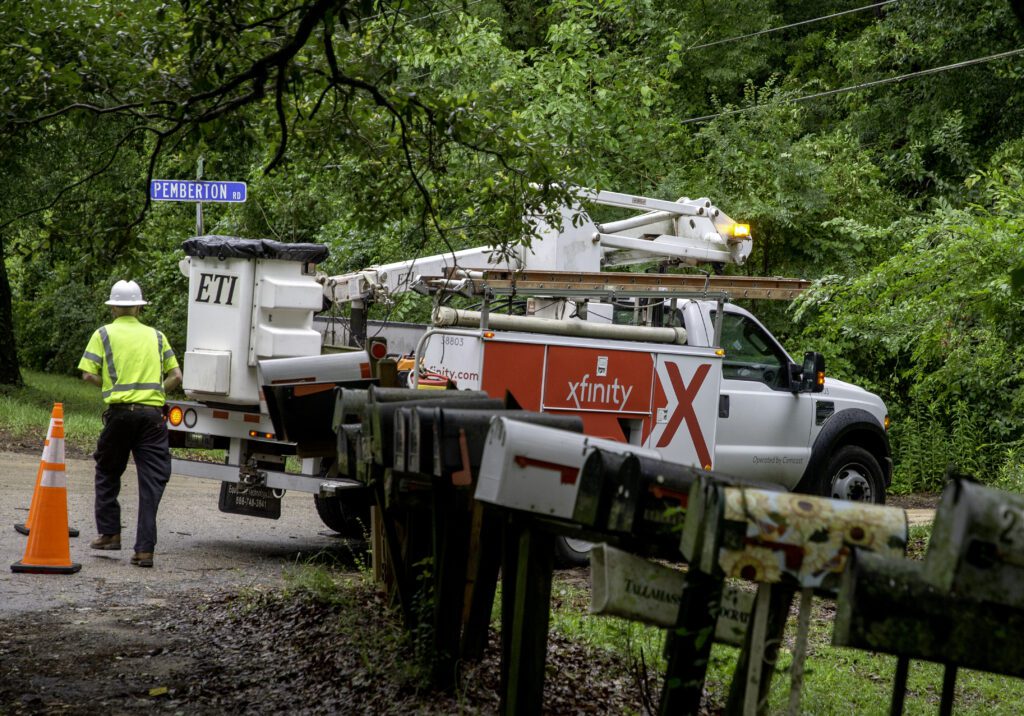 Tech walks next to an Xfinity truck in as repairs are made in Tallahassee