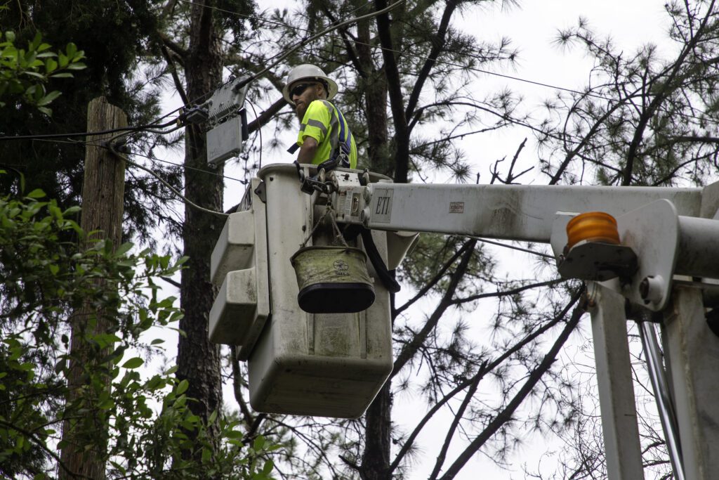 Tech in a bucket works on damaged lines