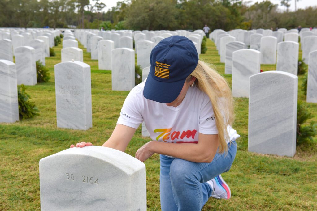 person touching a grave at cemetery