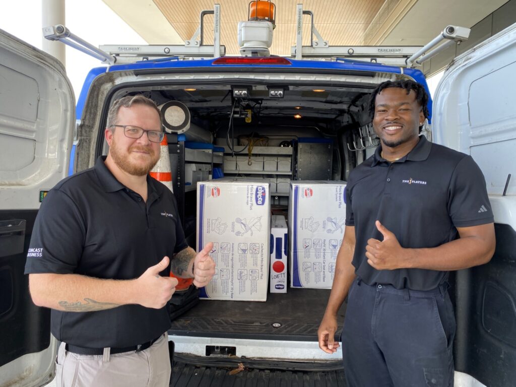 Candill and Lunsford smile with gifts from Operation Shower that they helped deliver to the families' homes.
