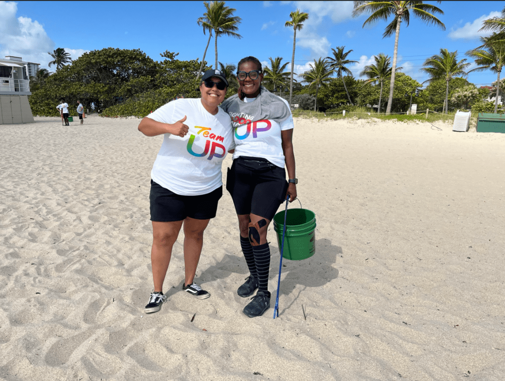 two women at the beach cleaning