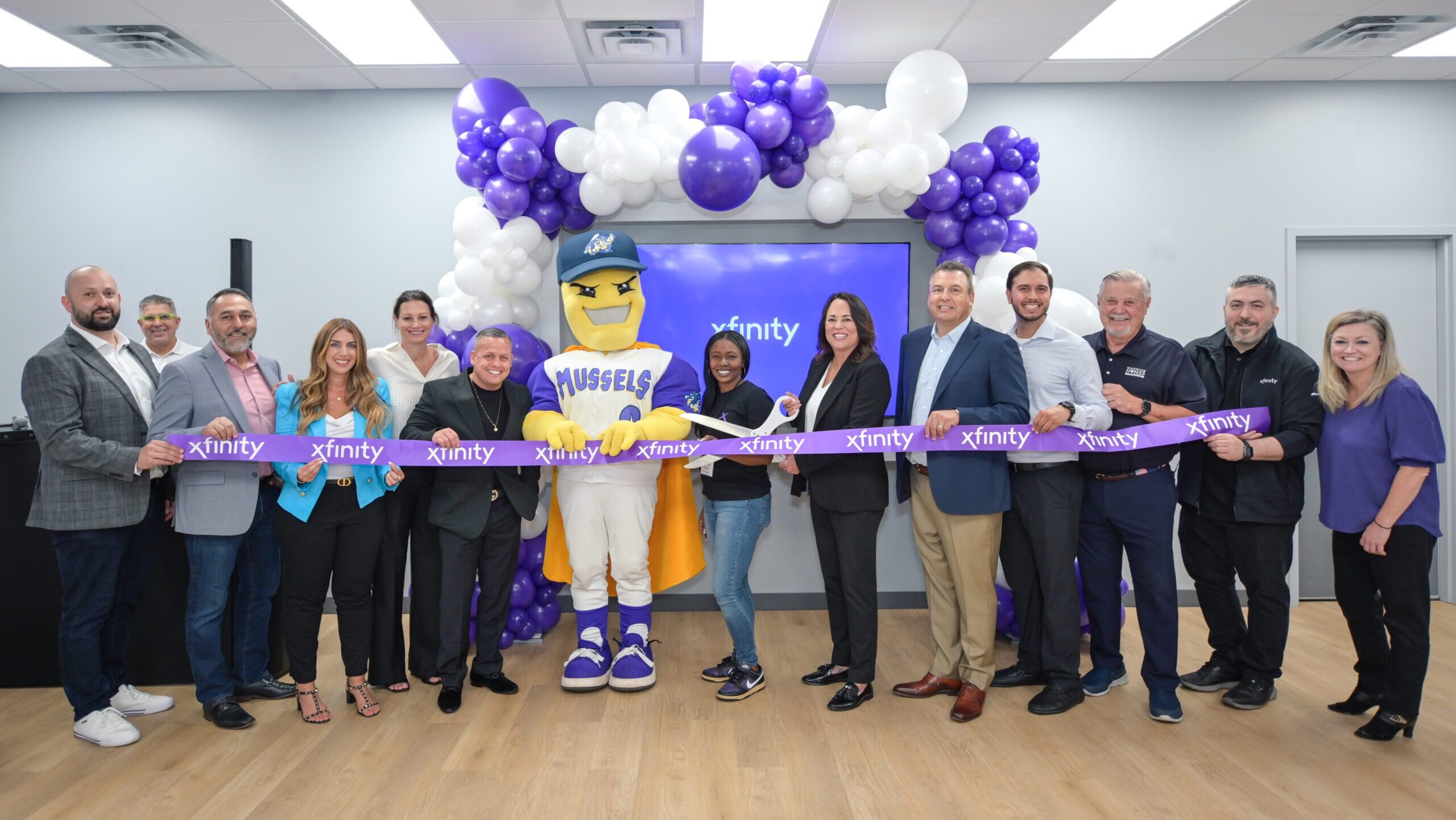 People holding a ribbon for the grand opening of a store