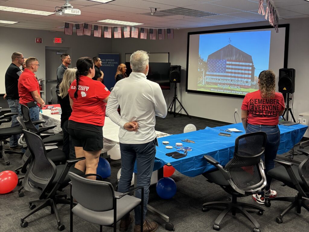 people around a table pay tribute to the American flag.