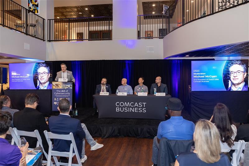 A moderator discusses cybersecurity with panelists.