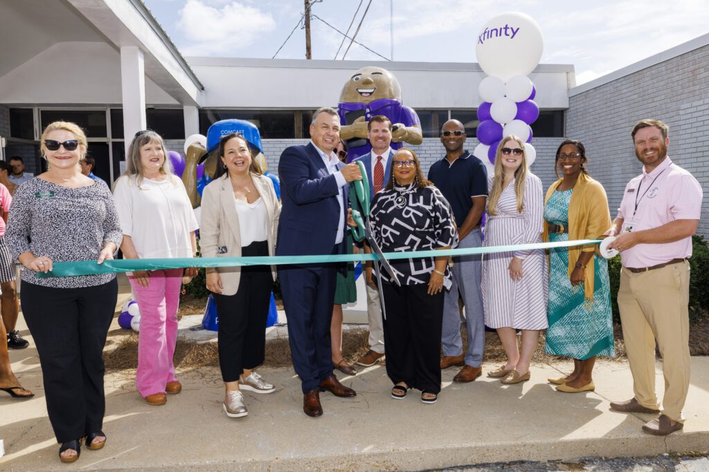 Comcast technicians help unveil two new peanut sculptures outside the Oates Street Xfinity Store in Dothan, AL.